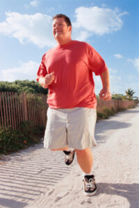 Overweight man running on beach