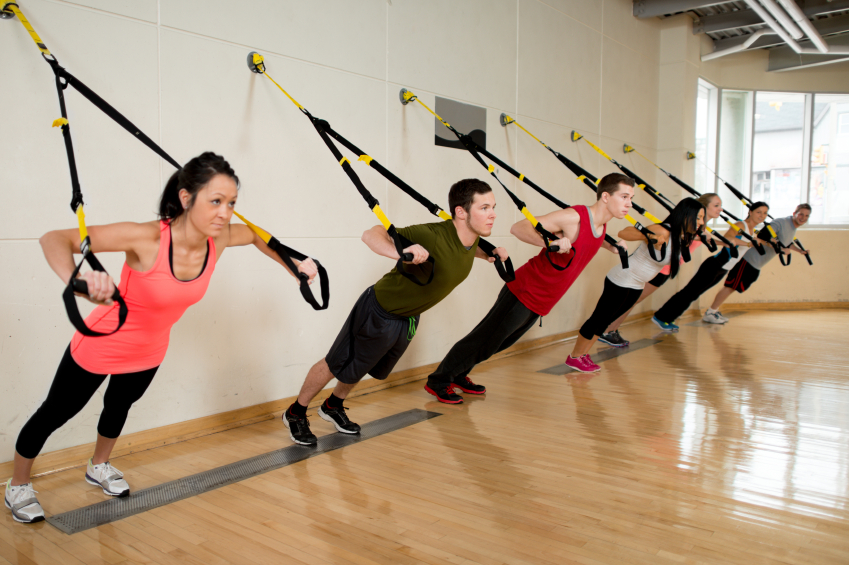 A group of people doing suspension training at the gym.